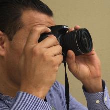 Hombre enfocando en la cámara para toma de fotografía