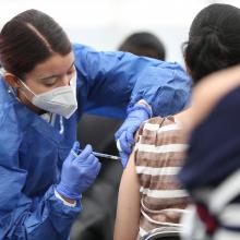 Enfermera aplicando una vacuna a una mujer 