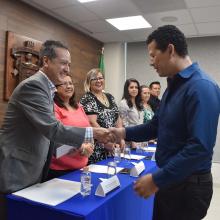 Egresado de la Licenciatura en Tecnologías e Información recibiendo sus documentos de manos del coordinador de carrera