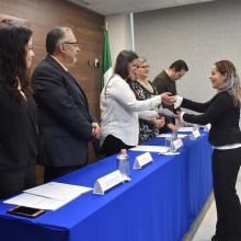 Egresada de la Licenciatura en Desarrollo Educativo recibiendo sus documentos de manos del coordinador de carrera