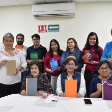 Participantes del taller muestran su libro