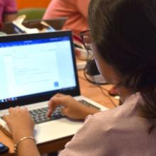 Mujer escribe en su lap top 