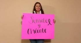 Mujer con letrero "Súmate y chécate"